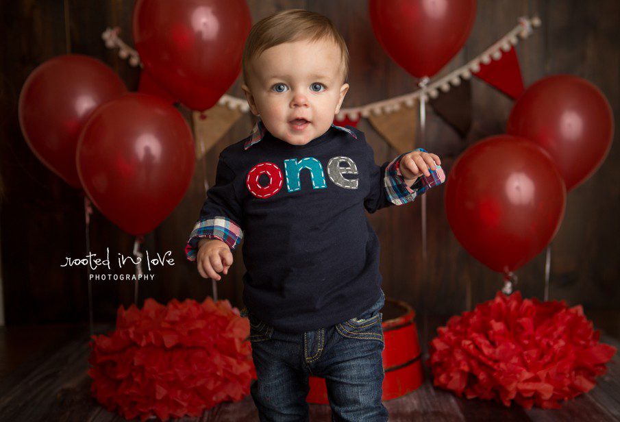 A baby boy wearing a "one" shirt.