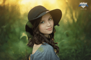 Woman in hat looking away in field.